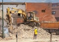 Caterpillar excavator loading a pile of crushed rock in the bed of an orange truck in Marrakesh, Morocco.