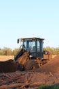 Caterpillar front end loader with a pile of dirt and tree`s out in the country.