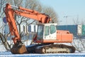 Caterpillar white-orange excavator close up in the sunny February day Royalty Free Stock Photo