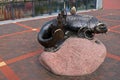 A catfish statue with a bridge Keeper`s booth on a large pink stone near a High bridge on the Pregol river embankment paved with g