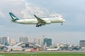 Cathay pacific airbus a350-900 fly over urban areas with skyscrapers to prepare landing