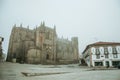 Cathedral facade and old buildings in the morning mist