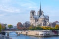 Cathedral of Notre Dame de Paris sunny autumn afternoon. Embankment of the Seine River. The natives and tourists take a walk and Royalty Free Stock Photo