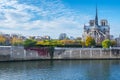 Cathedral of Notre Dame de Paris sunny autumn afternoon. Embankment of the Seine River. The natives and tourists take a walk and Royalty Free Stock Photo