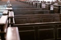 Cathedral pews. Rows of benches in christian church. Heavy solid uncomfortable wooden seats Royalty Free Stock Photo