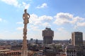 Cathedral statue and view of Milan cityscape with Torre Valesca