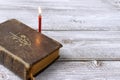 Catholic bible and red church burning candle on wooden background with copy space