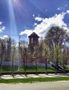 The Catholic Church, the blue sky, behind the green trees, in the sun