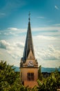Catholic church clock tower among tree crowns