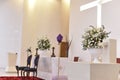 Catholic church prayer altar with flower arrangements and cross in the background Royalty Free Stock Photo