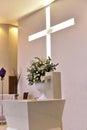 Catholic church prayer altar with flower arrangements and cross in the background Royalty Free Stock Photo