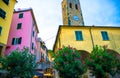 Catholic Church of San Giovanni Battista chiesa with clock tower, colorful buildings houses and flowers around in Monterosso villa