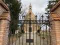 Catholic church with tower with bell and cross behind the wrought iron fence Royalty Free Stock Photo