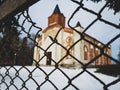 Catholic Church in winter behind a mesh fence