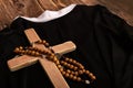 Catholic cross, rosary with beads lie on the black clothes of the priest Royalty Free Stock Photo