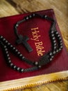 The Catholic cross on the rosary lies on the Holy Bible. Close-up. Faith, spirituality, religion, catholicism. Holy Scripture. Royalty Free Stock Photo