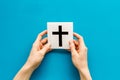 Catholic cross sign in hands - catholicism religion concept - on blue background top view copy space