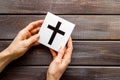 Catholic cross sign in hands - catholicism religion concept - on wooden background top view copy space