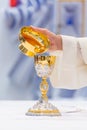 Catholic Holy Mass - golden chalice with wine on the altar