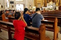 Catholic men and women kneel down and pray inside the Antipolo Cathedral or the Our Lady of Peace and Good Voyage church Royalty Free Stock Photo