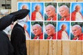 Catholic nuns looking at street banners of pope John Paul`s in Vatican city in Rome Italy