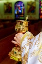 catholic priest with chalice cup during consecration ceremony