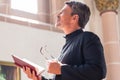 Catholic priest reading bible in church