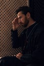 Catholic priest wearing cassock in confessional booth