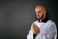 Catholic priest in white surplice prays