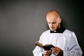 Catholic priest in white surplice reading bible Royalty Free Stock Photo