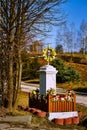 Catholic shrine with flowers and yellow decorations on the background of the field and road Royalty Free Stock Photo