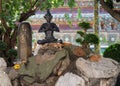 Cats have a rest near the sculpture of a meditating person in the territory of a Buddhist monastery