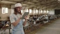 Cattleman using digital tablet for work at goat farm