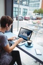 Caucacian businesswoman sitting at desk using laptop with statistical data on screen Royalty Free Stock Photo