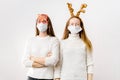 Caucasiam young women on white background with santa hat and reindeer. Christmas quarantine Royalty Free Stock Photo