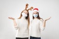 Caucasiam young women on white background with santa hat and reindeer. Christmas quarantine Royalty Free Stock Photo