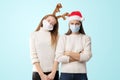 Caucasiam young women on white background with santa hat and reindeer. Christmas quarantine Royalty Free Stock Photo