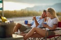 young adult couple talking and smiling, looking each other, sitting outdoor at sunset Royalty Free Stock Photo