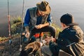 The first joint fishing of adult father and teen son in warm, sunny day. Royalty Free Stock Photo