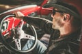 Caucasian American Cowboy Behind Vintage Classic Pickup Wheel