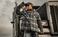 Caucasian American Trucker in Front of His Black Semi Truck Tractor Royalty Free Stock Photo