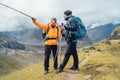Caucasian and Asian men with backpacks together resting Makalu Barun Park trekking route near Khare. Man pointing at Mera peak