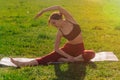 Caucasian athlete tilts to the side while sitting on a sports mat