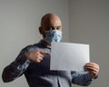 Man in protective face mask with white blank sheet poster mockup Royalty Free Stock Photo