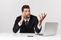 Caucasian attractive businessman worried and tired talking on mobile phone sitting at office desk working in stress Royalty Free Stock Photo