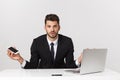 Caucasian attractive businessman worried and tired talking on mobile phone sitting at office desk working in stress Royalty Free Stock Photo