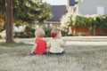 Caucasian babies sitting together in field meadow outside Royalty Free Stock Photo