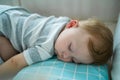 Caucasian baby boy toddler sleep on kids bed with comforter in bedroom. Adorable newborn infant having sweet dream, lying down on Royalty Free Stock Photo