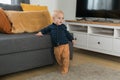 Caucasian baby newborn infant making first steps. Cute toddler kid child son boy learning walking creeping on living Royalty Free Stock Photo