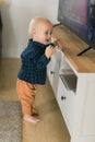 Caucasian baby newborn infant making first steps. Cute toddler kid child son boy learning walking creeping on living Royalty Free Stock Photo